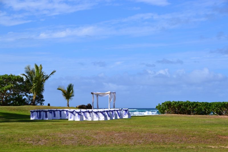 A wedding ceremony setup on the lawn at Loulu Palms, white chairs facing the ocean